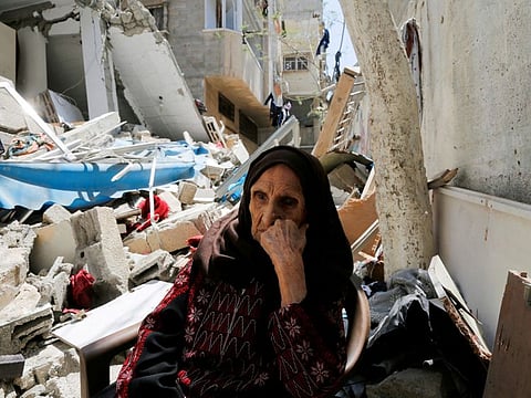 Muhana, 97, who was forced to flee Al Masmiyya village during the 'Nakba', or catastrophe in the war surrounding Israel's independence in 1948 and whose house was destroyed in an Israeli strike in the recent Israel-Gaza fighting, sits in front of the rubble of her house, in Gaza City, May 14, 2023.  
