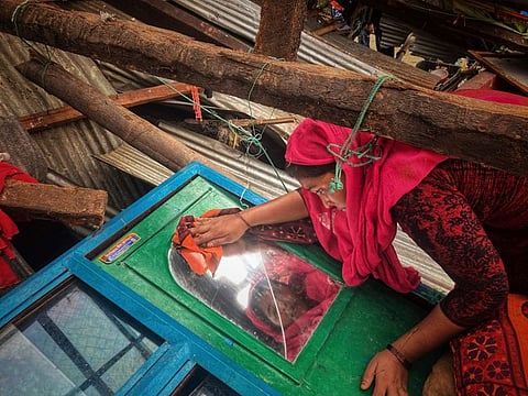 A woman salvages belongings from her home damaged by Cyclone Mocha at Saint Martin island in Cox's Bazar, Bangladesh, Monday, May 15, 2023. Mocha largely spared the Bangladeshi city of Cox's Bazar, which initially had been in the storm's predicted path. Authorities had evacuated hundreds of thousands of people before the cyclone veered east. (AP Photo/Al-emrun Garjon)