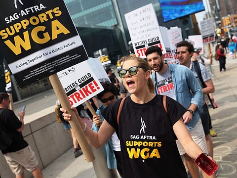 Writers Guild of America East members walk a picket line at the Disney Upfront event at the Javits Center on May 16, 2023 in New York.