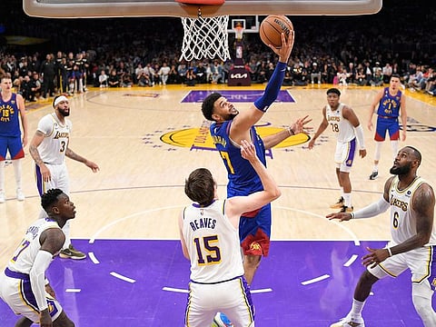 Denver Nuggets guard Jamal Murray, top, shoots over Los Angeles Lakers guard Austin Reaves (15) in the second half of Game 3 of the NBA basketball Western Conference Final series in Los Angeles
