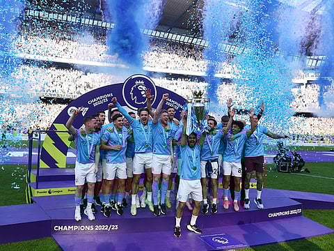 Manchester City's Ilkay Gundogan lifts the trophy as he celebrates with teammates after winning the Premier League 