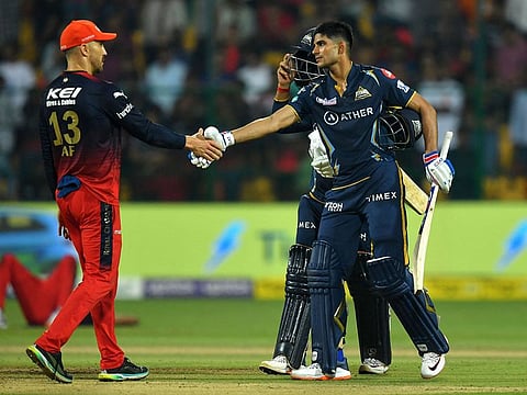 Royal Challengers Bangalore's captain Faf du Plessis (L) greets Gujarat Titans' Shubman Gill at the end of the Indian Premier League (IPL) Twenty20 cricket match between Royal Challengers Bangalore and Gujarat Titans at the M Chinnaswamy Stadium in Bengaluru on May 21, 2023.