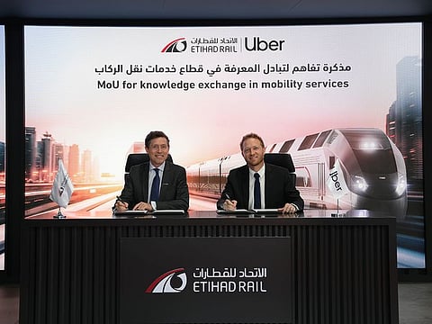 Etihad Rail's Nicolas Petrovic (left) and Uber's Frans Hiemstra sign the MoU.