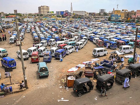 Minivan buses and tuk-tuks (motorised rickshaws) wait for passengers at a bus station in Port Sudan on May 23, 2023.  
