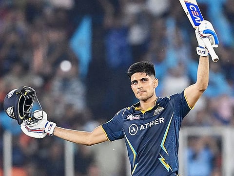 Gujarat Titans' Shubman Gill raises his bat to celebrates scoring a century during the IPL second qualifier match against Mumbai Indians at the Narendra Modi Stadium in Ahmedabad on May 26, 2023.  