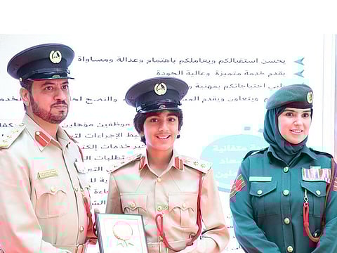 Hussain Yousef Merza (centre) receives a souvenir from Colonel Khalifa Ali Rashed, deputy director of Al Muraqqabat Police Station. Also seen is Sergeant Manal Al Juhari, the coordinator of the School Security initiative at the station.