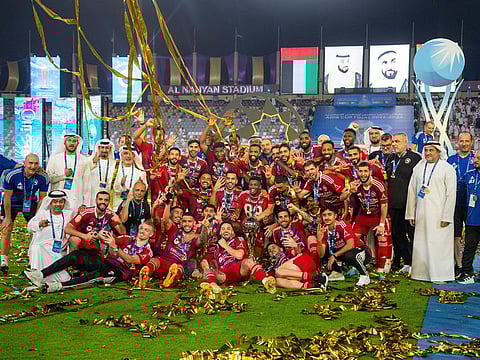 Sharjah players celebrate with the trophy after winning the final at Al Nahyan Stadium.