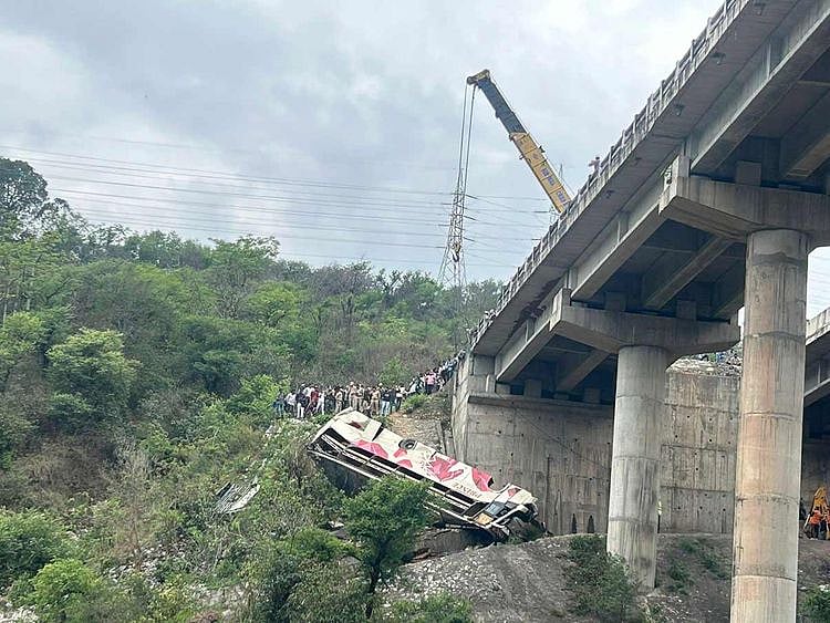 Rescuers prepare to use a crane after a bus carrying Hindu pilgrims to a shrine skid off a highway bridge into a Himalayan gorge near Jammu