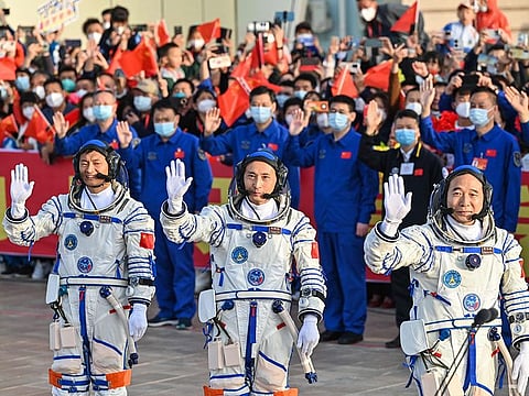 Gui Haichao (L) payload expert, Zhu Yangzhu (C) space flight engineer and commander Jing Haipeng (R) wave during the seeing-off ceremony before boarding a Long March-2F carrier rocket carrying the Shenzhou-16 Manned Space Flight Mission at the Jiuquan Satellite Launch Centre in China's northwestern Gansu province on May 30, 2023. 