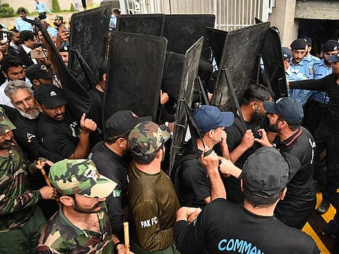 Security personnel with ballistic shields escort former Pakistan's prime minister Imran Khan (unseen) as he leaves from Islamabad High court in Islamabad on May 31, 2023, after Khan was granted bail in multiple cases. 