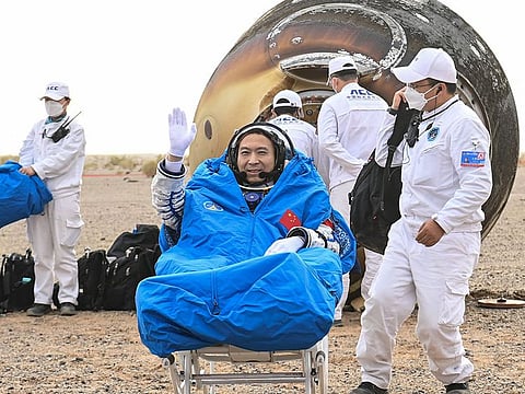 Taikonaut Fei Junlong waves as he leaves the capsule of the Shenzhou-15 spaceship after landing in China's Inner Mongolia