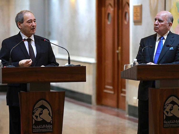 Iraqi Foreign Minister Fuad Hussein (R) and his Syrian counterpart Faisal Mekdad