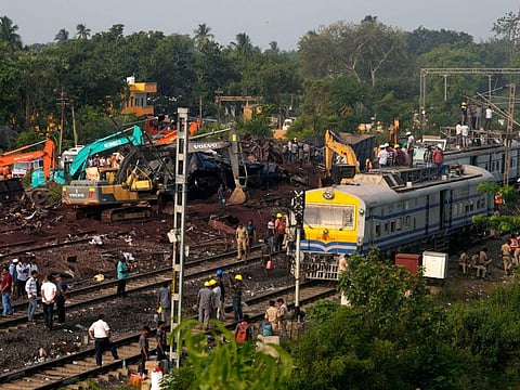 People watch the site where trains that derailed, in Balasore district, in the eastern Indian state of Orissa, Sunday, June 4, 2023.