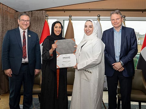 Mona Al Marri (second from left) presents the programme completion certificate to Fatema Al Nuaimi, Executive Vice President, ADNOC
