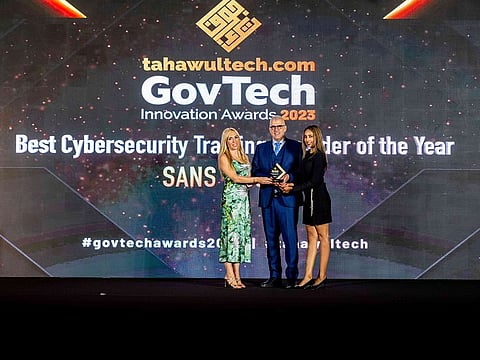Ned Baltagi and Karshini Perera of SANS Institute receiving the award from Veronica Martin of CPI Media Group
