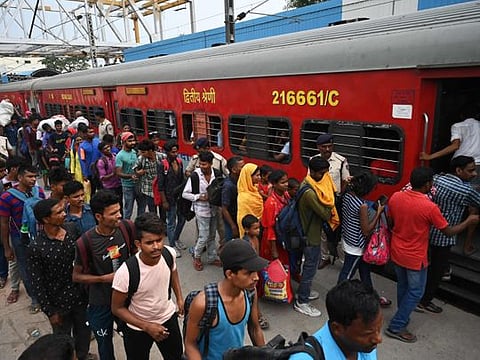 Passengers queue along a platform to board the Chennai bound Coromandel Express at Shalimar station near Kolkata on June 7, 2023. 