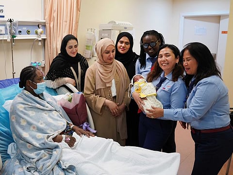 A RTA delegation during their visit to a woman who delivers a baby aboard RTA intercity bus to Ajman
