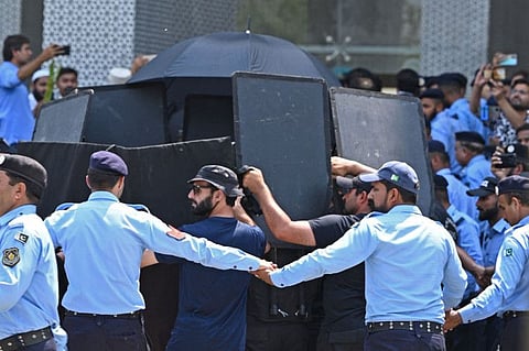 Security personnel with ballistic shields escort former Pakistan's prime minister Imran Khan, at the High Court in Islamabad on June 8, 2023.