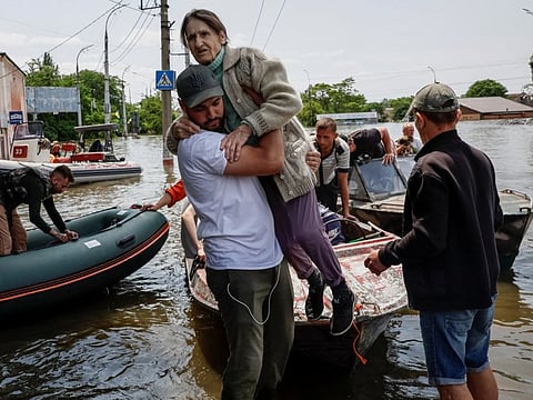 Volunteers evacuate local residents from a flooded area after the Nova Kakhovka dam breached, amid Russia's attack on Ukraine, in Kherson, Ukraine June 8, 2023. 