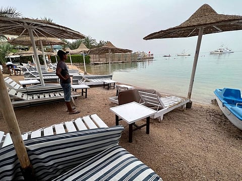A worker stands on one of the beaches that have been closed after a Russian citizen was killed in a shark attack near a beach at the Egyptian Red Sea resort of Hurghada, on June 9, 2023.  