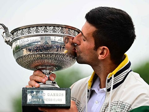 Serbia's Novak Djokovic kisses the Musketeers' Trophy after winning the French Open  in Paris on Sunday