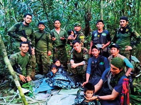In this photo released by Colombia's Armed Forces Press Office, soldiers and Indigenous men pose for a photo with the four Indigenous children who were missing after a deadly plane crash, in the Solano jungle, Caqueta state, Colombia, Friday, June 9, 2023. Colombian President Gustavo Petro said Friday that authorities found alive the four children who survived a small plane crash 40 days ago and had been the subject of an intense search in the Amazon jungle.  