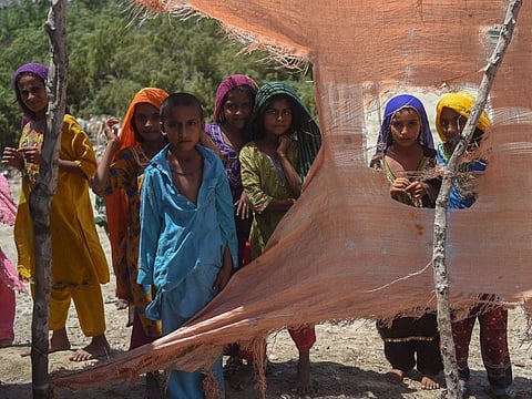 Children wait to be evacuated before the onset of cyclone, in Sujawal district, Sindh province.