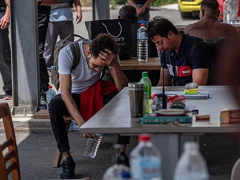 Members of a family of a missing person search for information after shipwreck survivors transferred to a Greek migrant camp in Malakasa, near Athens, on June 16, 2023. 