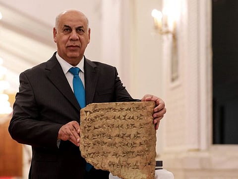 Iraqi Culture Minister Ahmed Fakak Al Badrani presents a 2,800-year-old stone tablet during a press conference in Baghdad, after it was handed over by the Italian authorities to the Iraqi president during his recent visit to Bologna, on June 18, 2023.