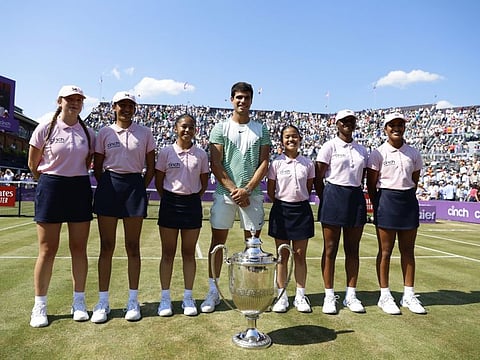 Spain's Carlos Alcaraz with his trophy and the ball kids after winning the final against Australia's Alex de Minaur Tennis at Queen's Club, London on Sunday.