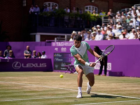 Carlos Alcaraz returns the ball to Alex de Minaur during their men's singles final at the Queens Club tournament in London on Sunday.
