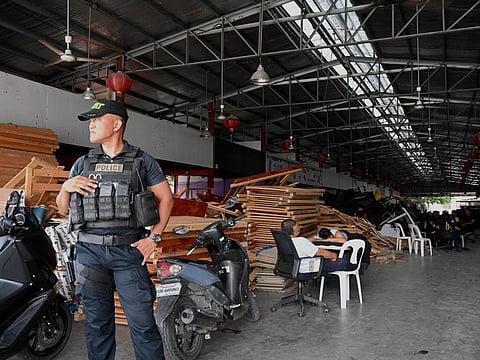 A policeman stands guard inside a compound, where police raided buildings in Metro Manila on June 27, 2023. 