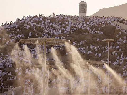 Pilgrims gather on the Mount of Mercy at the plain of Arafat as water mist is sprayed due to high temperature outside the holy city of Mecca, Saudi Arabia, on June 27, 2023.  