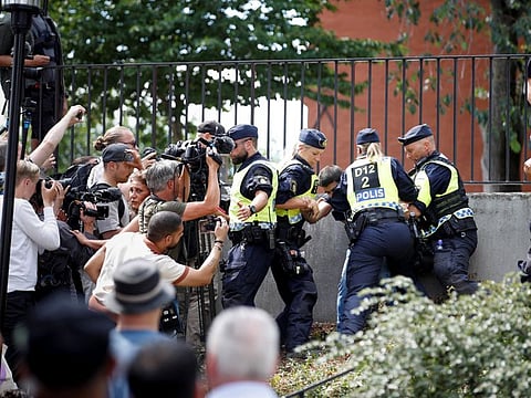 Police officers intervene as people protest “vile” and “despicable” act outside Stockholm's central mosque on June 28, 2023.  