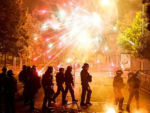 French police stand in position as fireworks go off during clashes with youth, after the death of Nahel, a 17-year-old teenager killed by a French police officer during a traffic stop, in Nanterre, Paris suburb, France, June 30, 2023. 