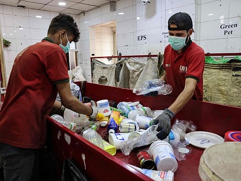 Employees at Lebanon Waste Management (LWM), a sorting facility that treats dry solid waste, handle the newly received recyclable waste in the back of their "Drive Throw" booth in Beirut, on June 22, 2023.