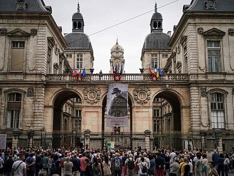 People gather in front of the city hall Monday, July 3, 2023 in Lyon, central France, in a show of solidarity with the mayor of the Paris suburb of L'Hay-les-Roses after a burning car struck his home.