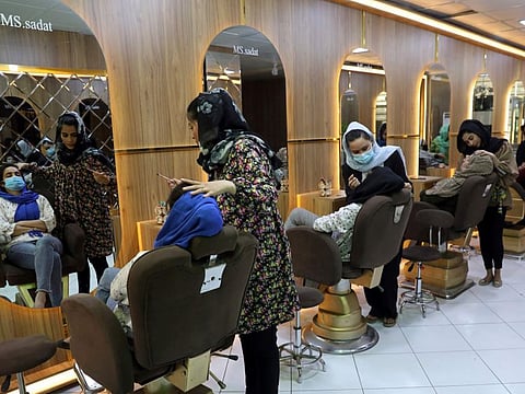 Beauticians put makeup on customers at Ms. Sadat's Beauty Salon in Kabul, Afghanistan, Sunday, April 25, 2021.  