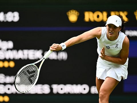 Poland's Iga Swiatek serves the ball to Spain's Sara Sorribes Tormo during their women's singles on the third day of the Wimbledon Championships at The All England Tennis Club in Wimbledon on Wednesday.