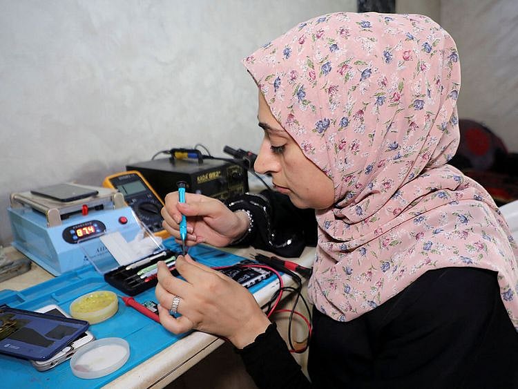 Palestinian woman Walaa Hammad repairs mobile phones at her home in Gaza City. 