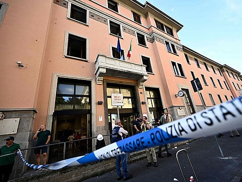 People stand outside a retirement home after a fire killed six residents, in Milan on July 7, 2023.