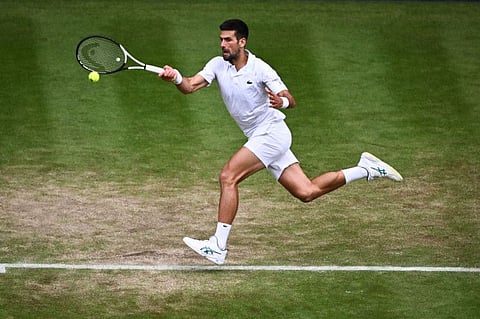 Serbia's Novak Djokovic fires a forehand return to Russia's Andrey Rublev during their men's singles quarter-finals match at The All England Tennis Club in Wimbledon on Tuesday.