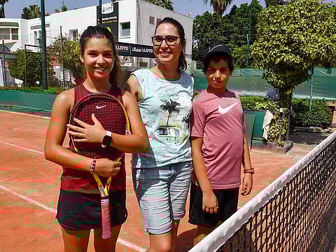 Nine-year-old Lina Chedi (L) poses for a picture with her mother Ibtissem Treimech (C) ahead of competes at a local tournament at the Tennis Club of Tunis in the Tunisian capital on July 15, 2023, on the day of Tunisian player Ons Jabeur's Wimbledon final. 