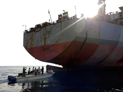 People in a small boat approach the beleaguered Yemen-flagged FSO Safer oil tanker in the Red Sea off the coast of Yemen's contested western province of Hodeida on July 15, 2023. 