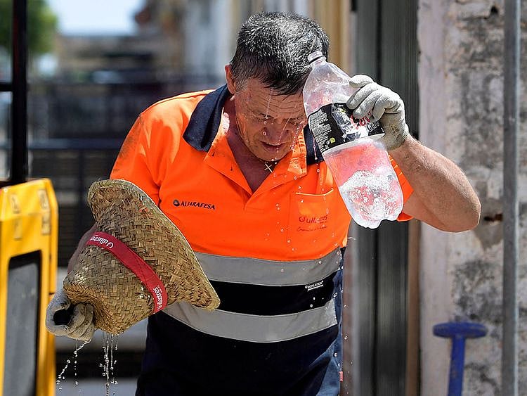 A worker cools off while working in a street during a heatwave in Sevilla, in the southern Spanish region of Andalusia, on July 17, 2023. Scorching weather gripped three continents, whipping up wildfires and threatening to topple temperature records as the dire consequences of global warming take shape. Little reprieve is forecast for Spain, where the met agency warned of a new heatwave on July 17 through July 19 taking temperatures above 40C in the Canary Islands and the southern Andalusia region. 