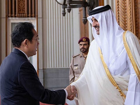 This handout picture released by the Qatar News Agency (QNA) shows Qatar's Emir Sheikh Tamim bin Hamad Al Thani (R) receiving Japan's Prime Minister Fumio Kishida in Doha on July 18, 2023.  