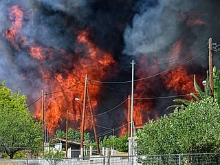 Fire near Athens burns homes as high winds compound heat wave
