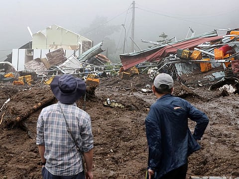 People watch their collapsed houses after a landslide caused by heavy rain in Yecheon, South Korea.