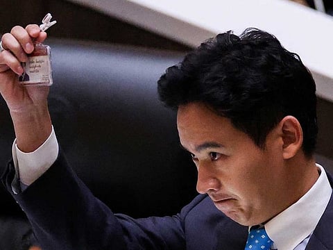Pita Limjaroenrat, leader of the Move Forward Party holds up his ID card at parliament after Thailand's Constitutional Court ordered his temporary suspension from the parliament, on the day of the second vote for a new prime minister, in Bangkok, Thailand, July 19, 2023. 