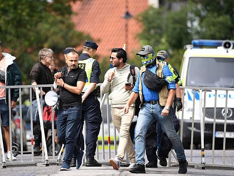 Protestor Salwan Momika (centre) is escorted by police to a location outside the Iraqi Embassy in Stockholm, Sweden, on July 20, 2023, where he burnt a copy of the Quran and the Iraqi flag.  